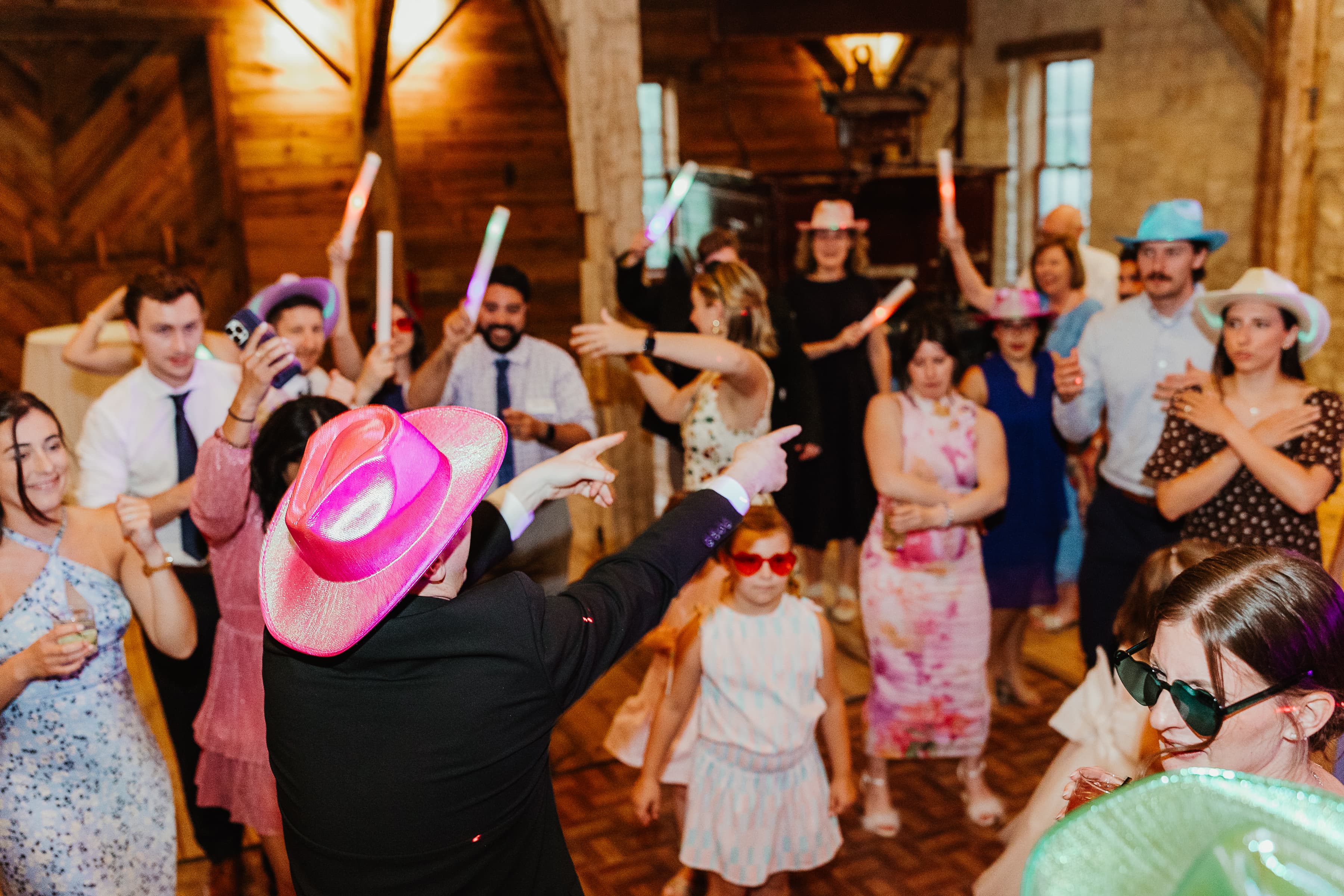 A lively party scene with guests dancing and celebrating in colorful hats and accessories.
